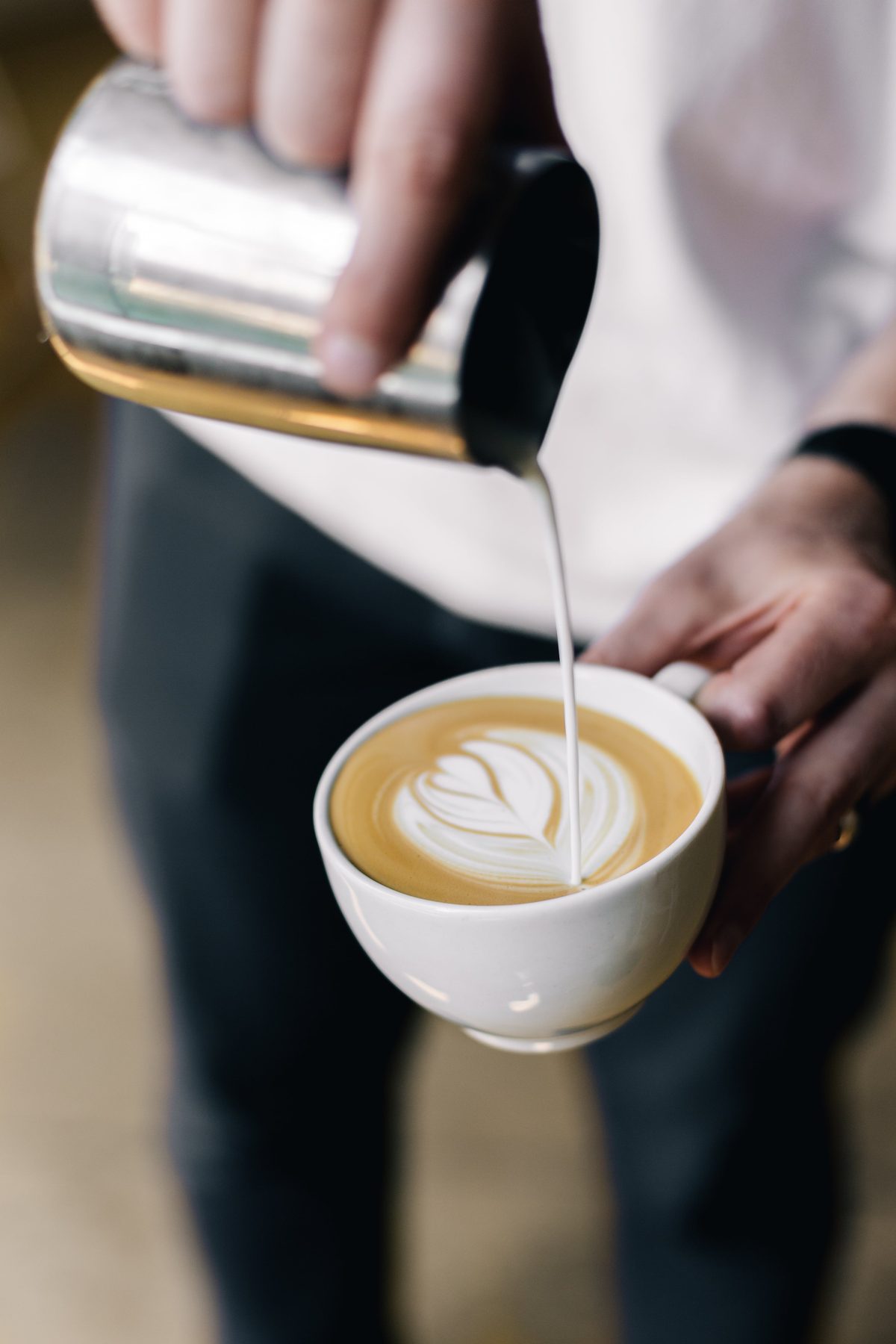 Melk wordt in een kop koffie geschonken