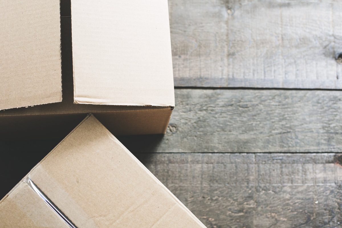 Twee open kartonnen verhuisdozen op een houten vloer